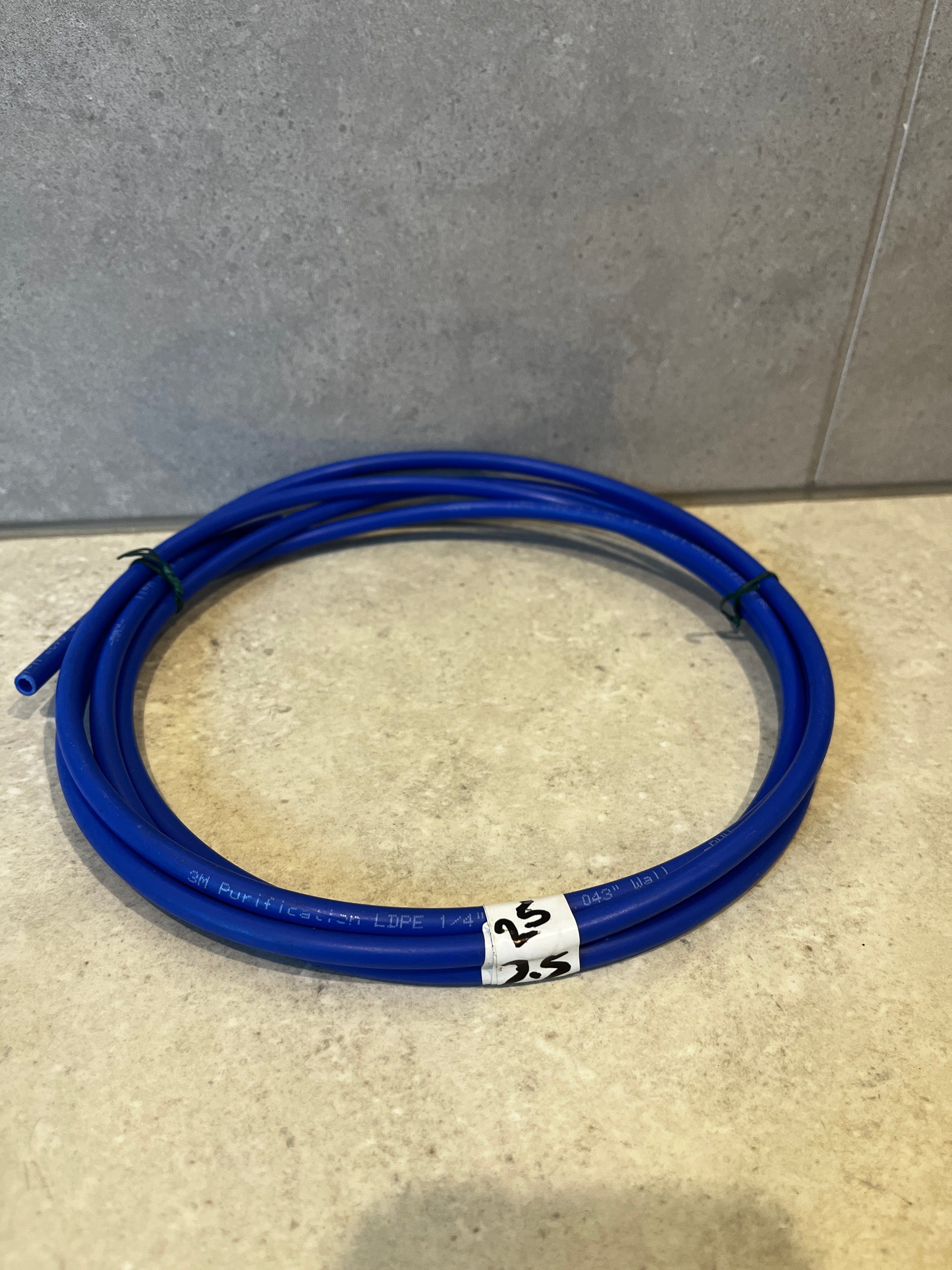 Coiled blue plastic tubing on a light surface