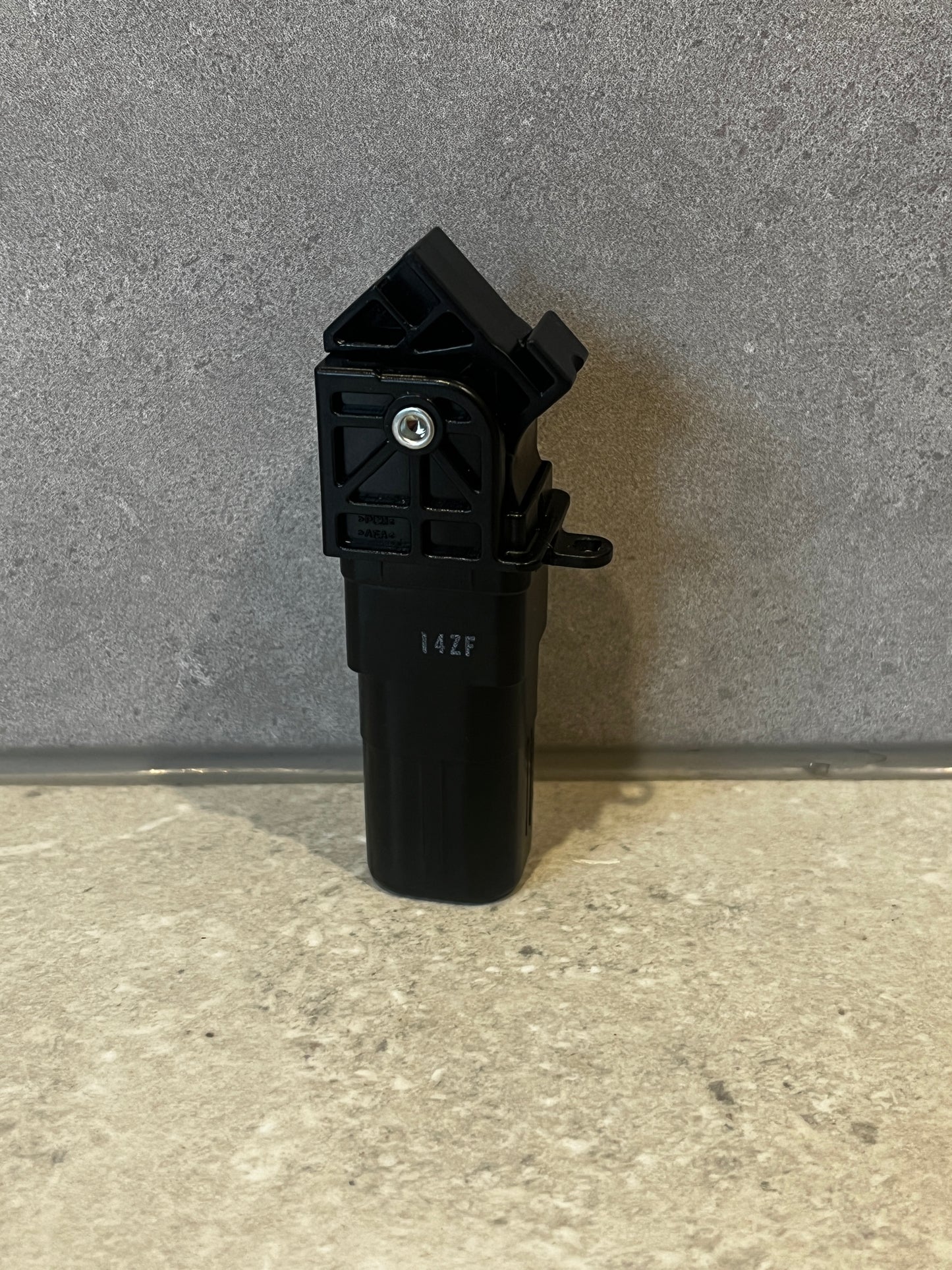 Black plastic automotive sensor with mounting brackets and integrated screw fastener