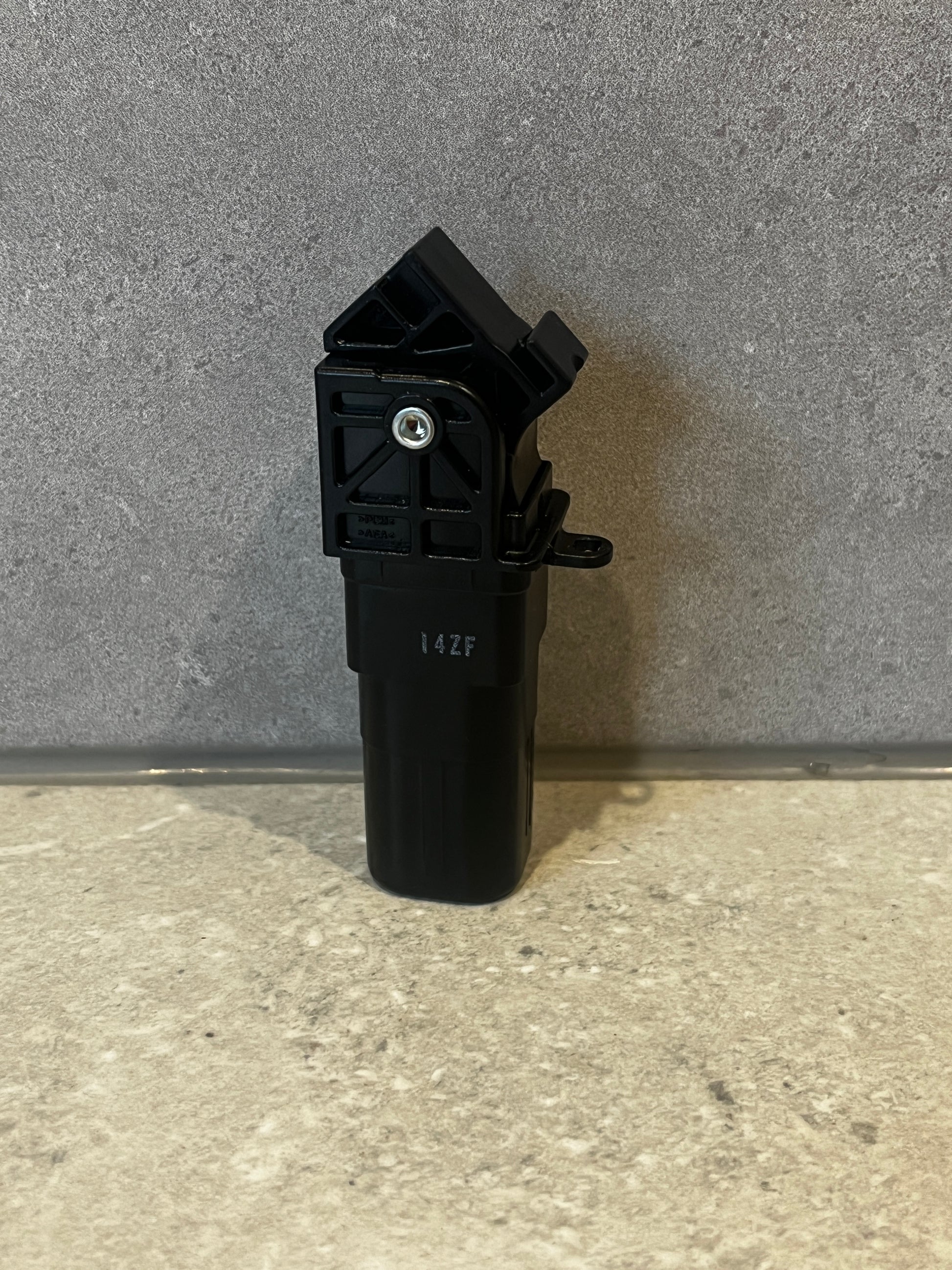 Black plastic automotive sensor with mounting brackets and integrated screw fastener