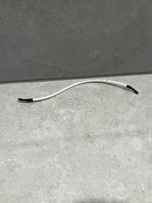 White insulated electrical wire with black-taped ends lying on a gray surface