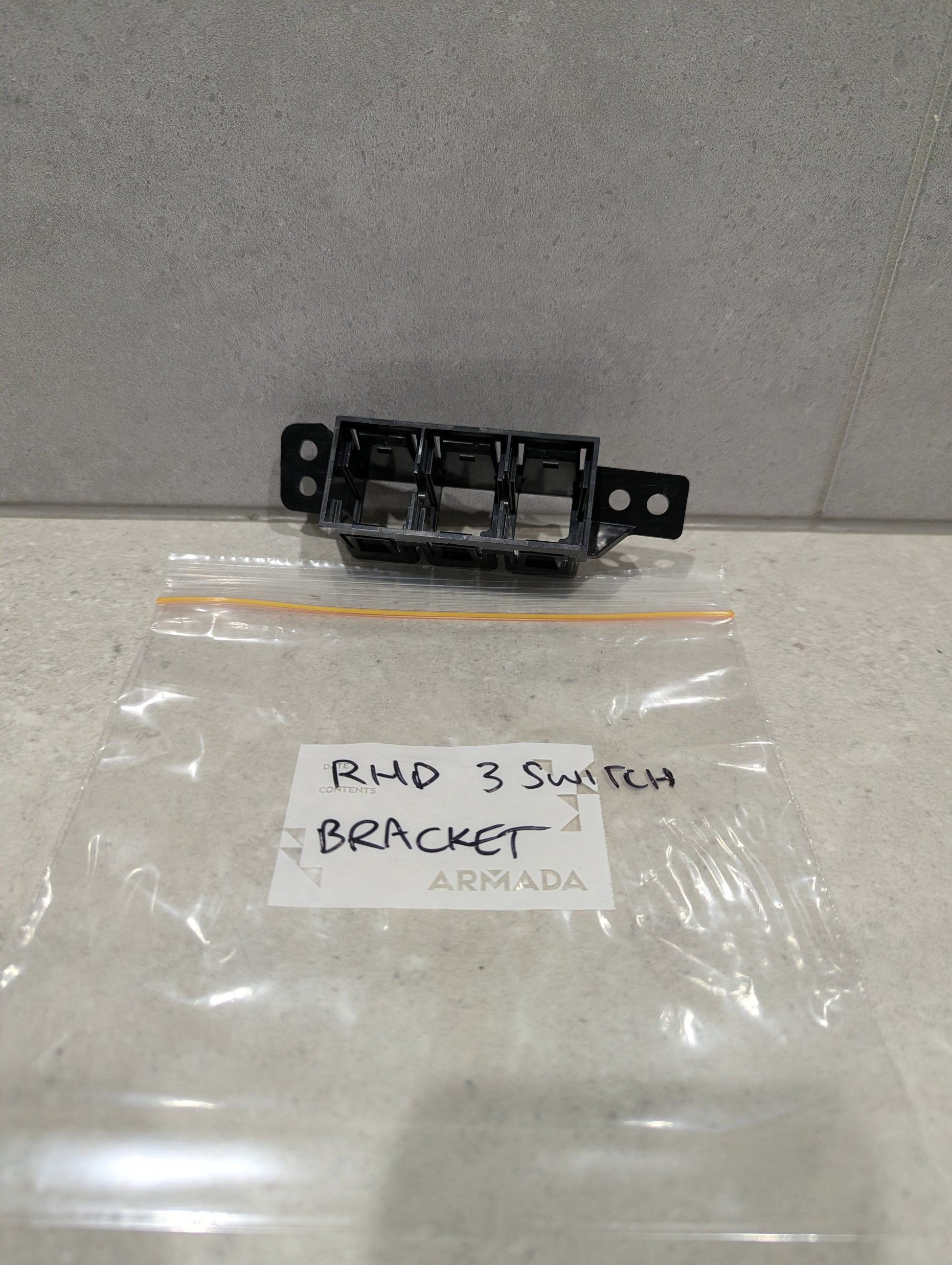 Armada RHD 3 switch bracket with labeled plastic bag on stone surface