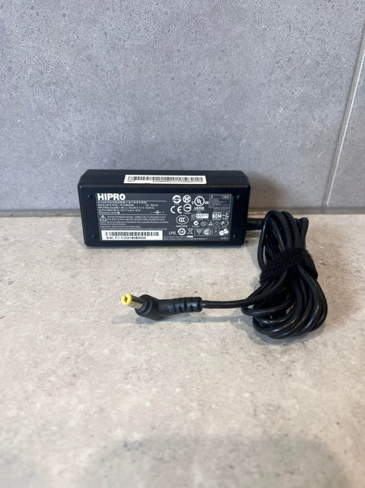HIPRO laptop power adapter with attached cord and plug on a stone surface