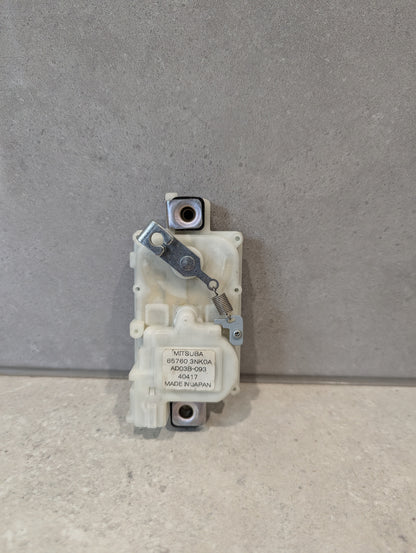 Front view of Mitsuba door lock actuator assembly with spring and label
