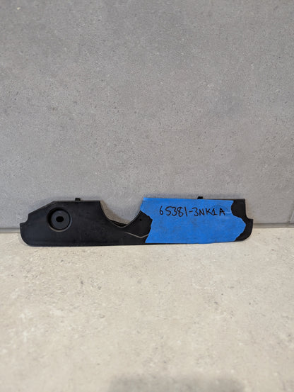 Black plastic automotive engine cover bracket with blue tape and handwritten part number 65381-3NK1A