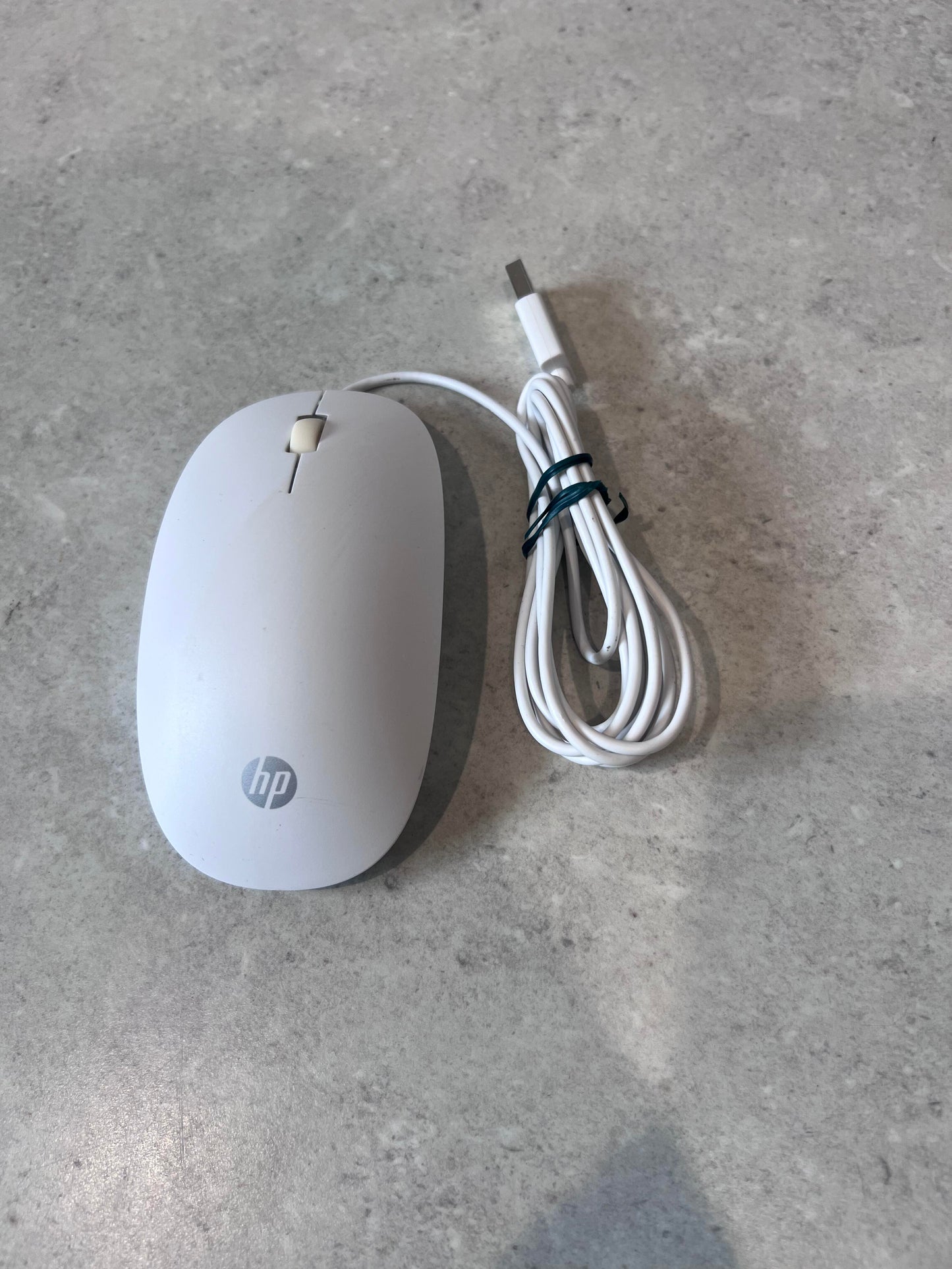Top view of white HP wired USB optical mouse with USB cable