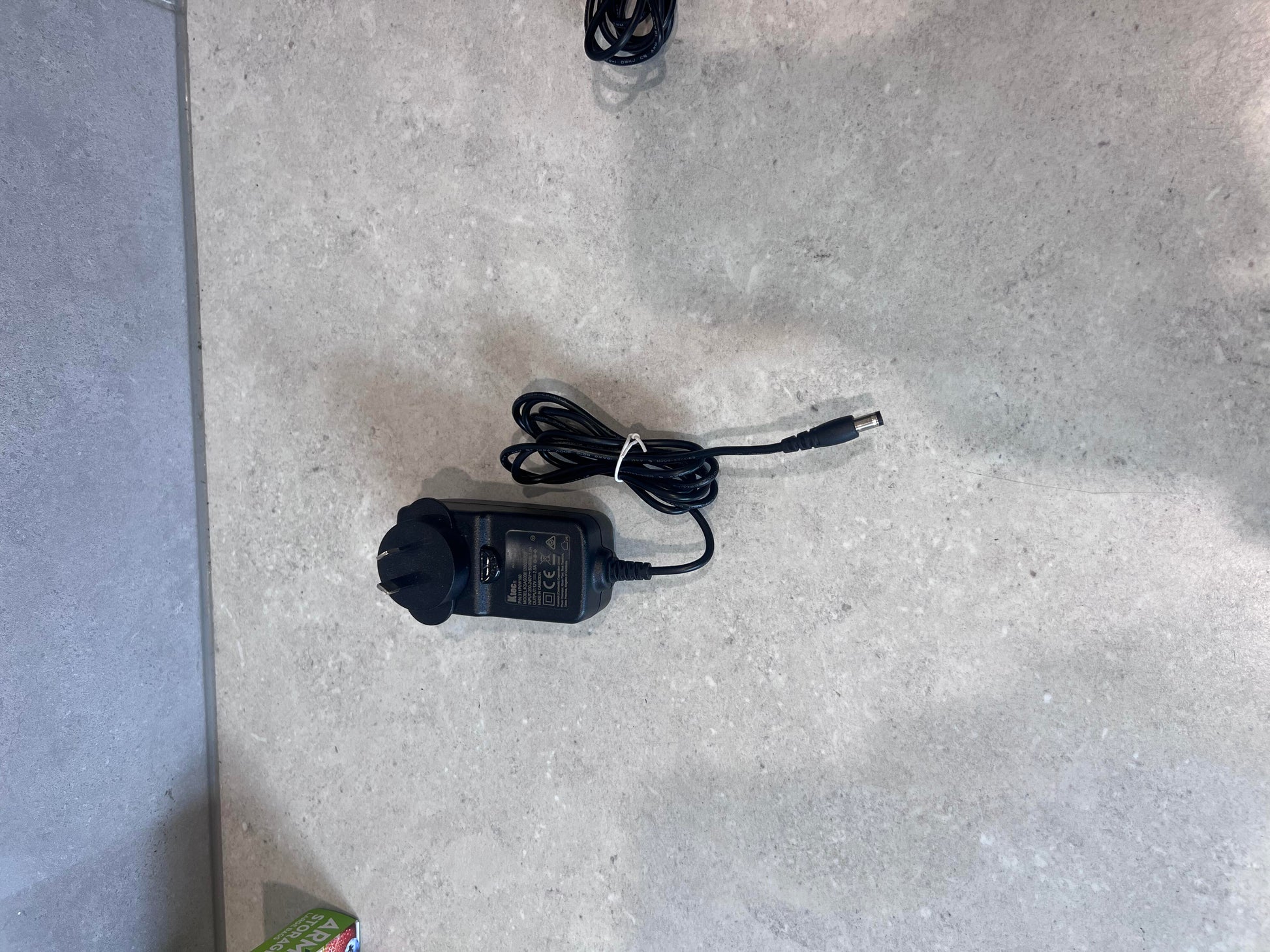 Ktec AC power adapter with attached cable on a gray surface
