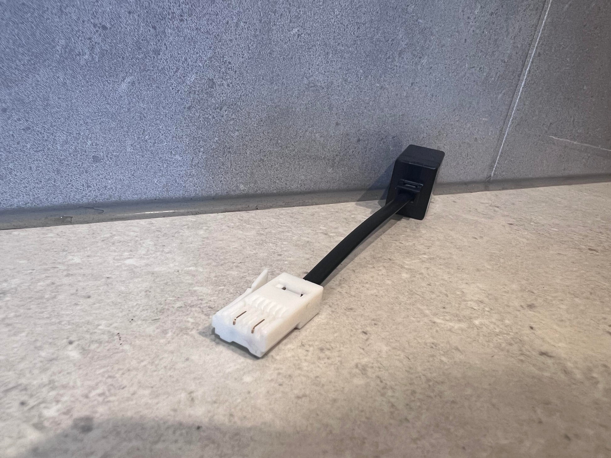 Ethernet RJ45 female to male adapter on a stone surface