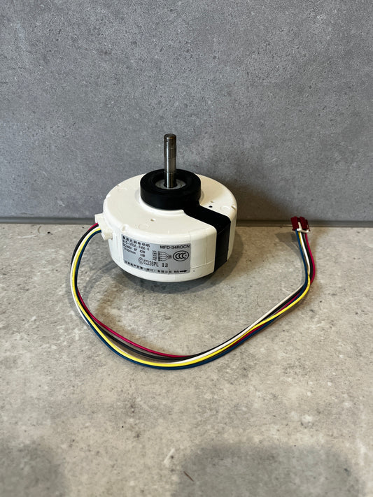 Electric fan motor assembly with color-coded wires on a stone surface