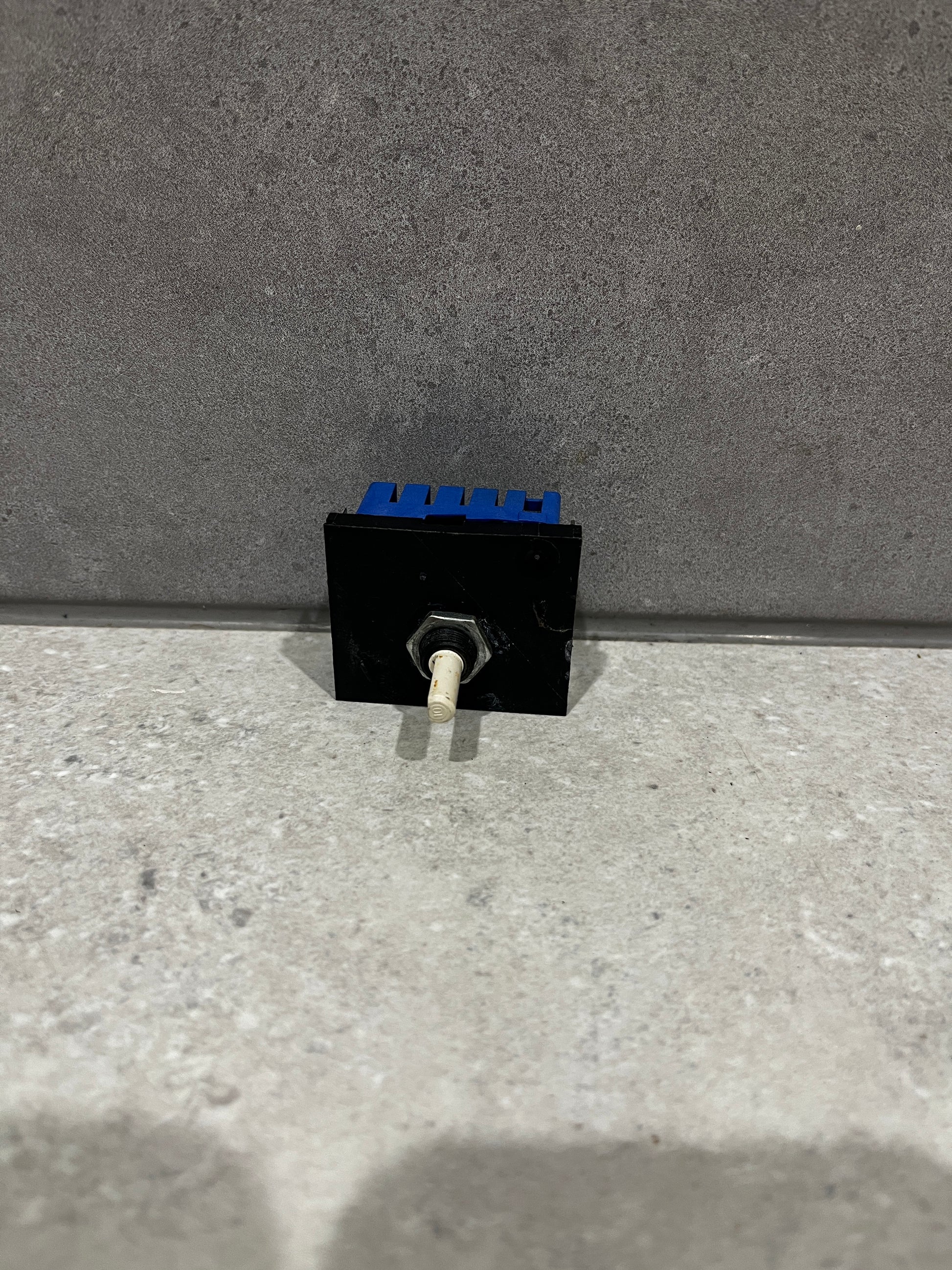 Electronic toggle switch module with black and blue housing and white lever