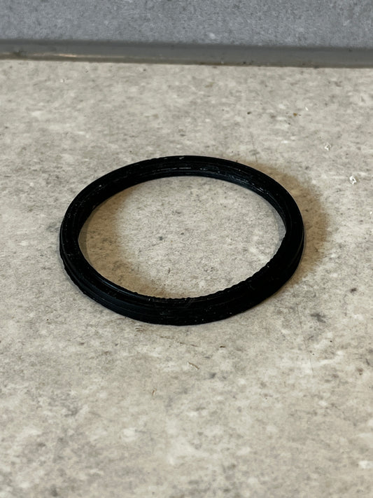 Black plastic O-ring gasket on a gray surface