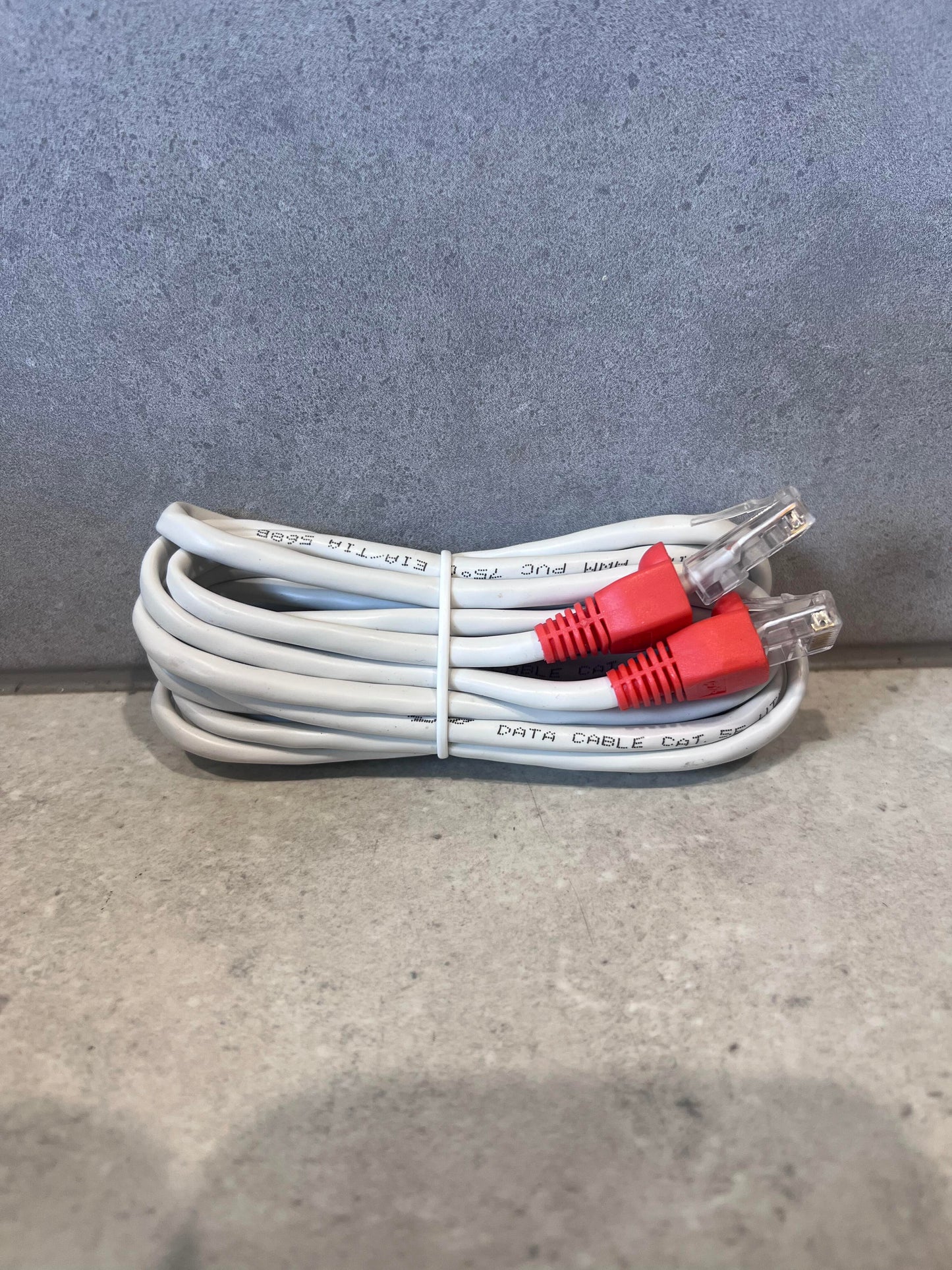 Coiled CAT 5E Ethernet cable with red RJ45 connectors