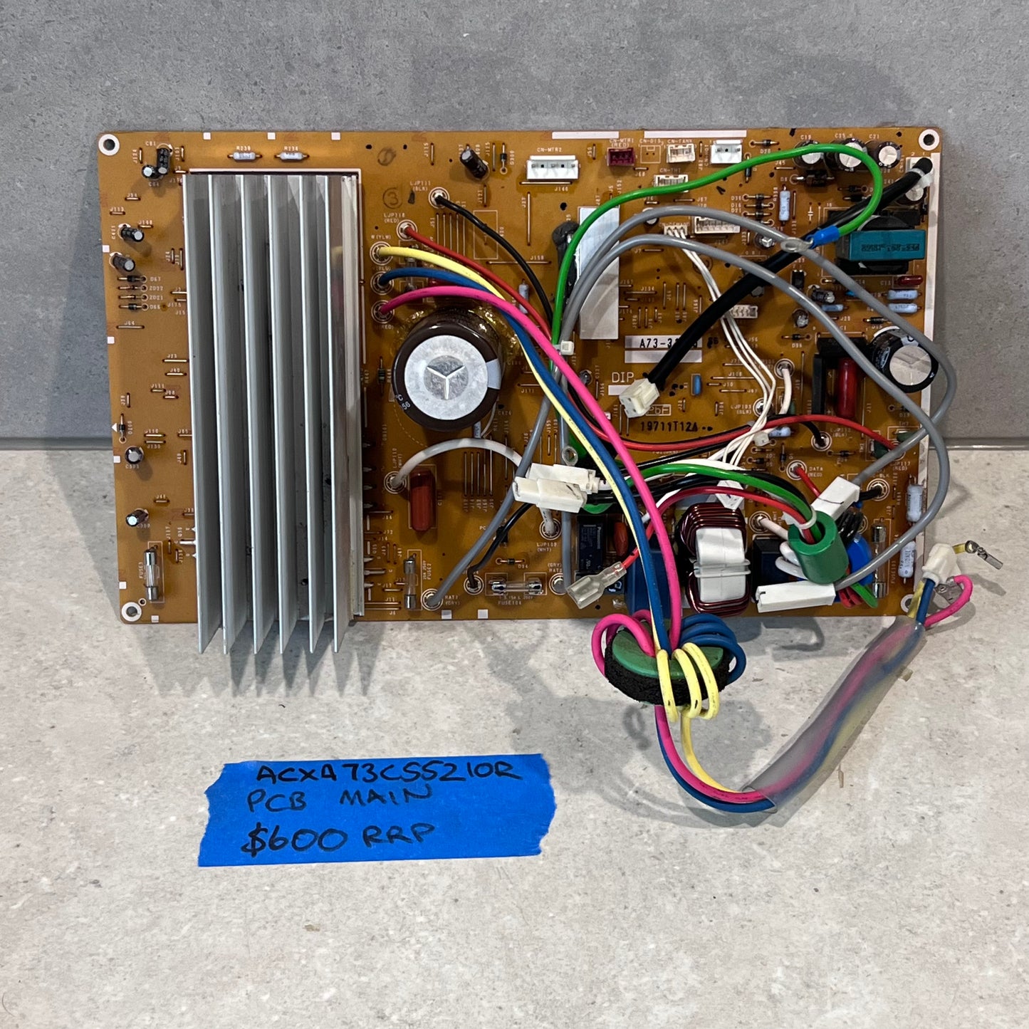 Main PCB board ACXA73C55210R with connectors and heat sink on a flat surface