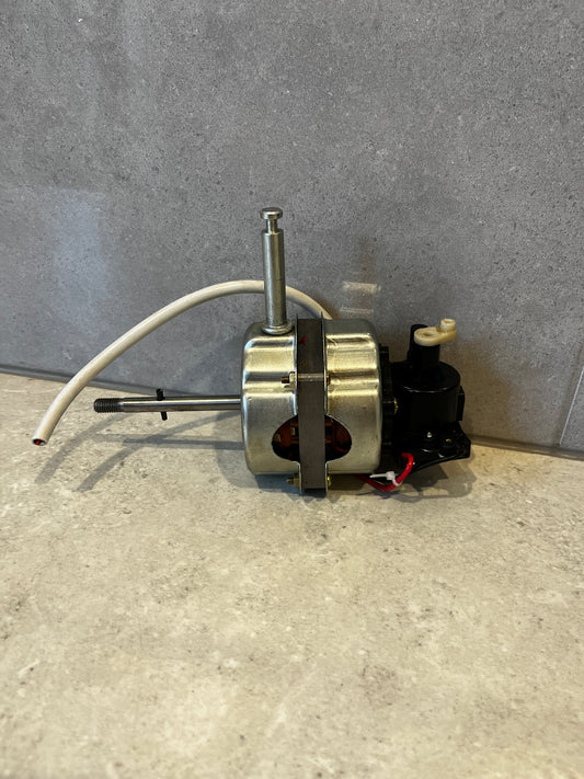 Side view of electric fan motor with metal housing and white wire against gray background