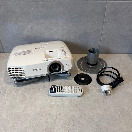 Epson EH-TW5200 projector with remote, power cable, and mounting accessories on countertop