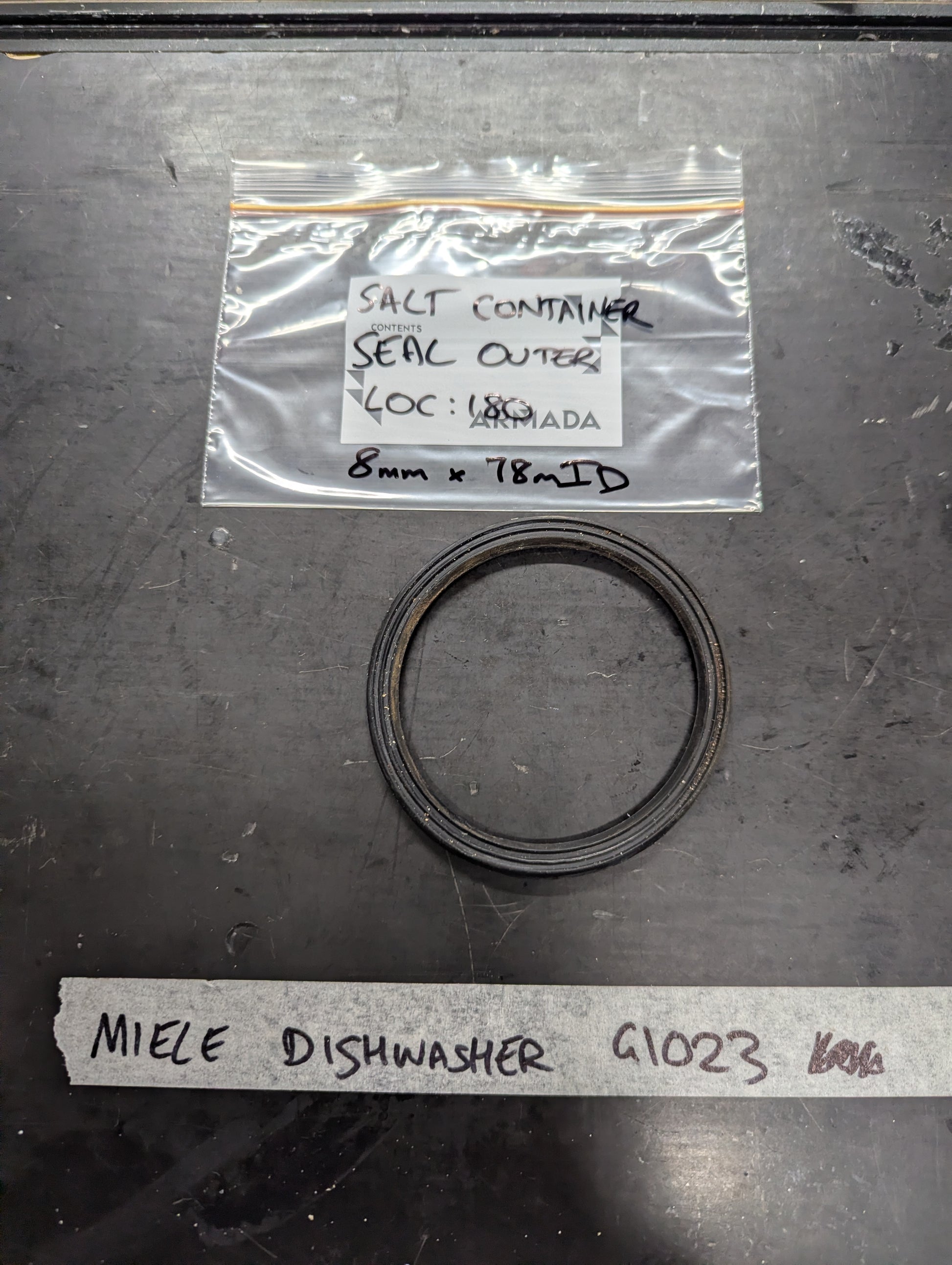Black rubber outer seal for Miele G1023 dishwasher salt container, labeled bag and item