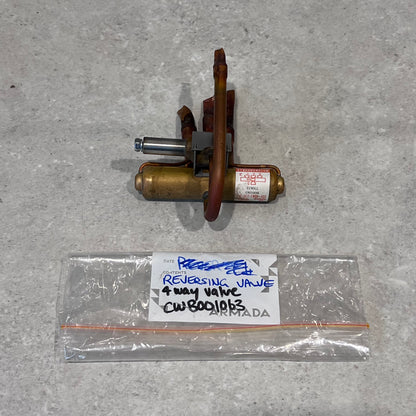 HVAC 4-way reversing valve with labeled storage bag on a light surface