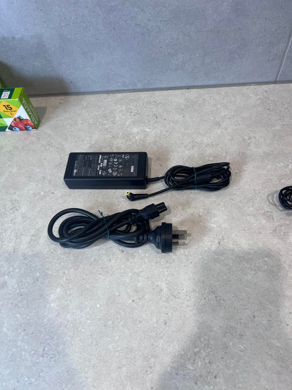 AcBel AC adapter with power cord on a countertop