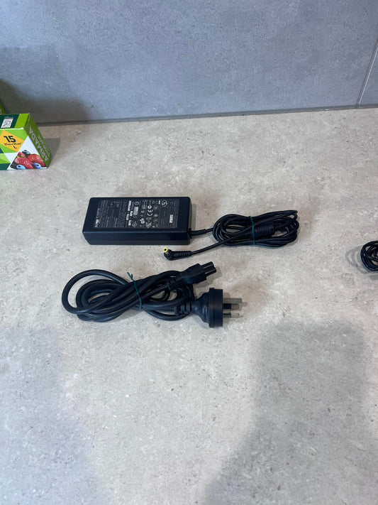 AcBel AC adapter with power cord on a countertop