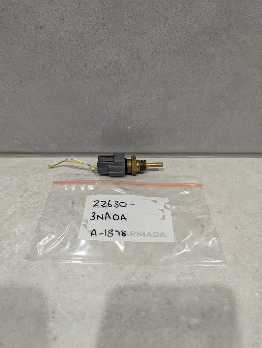 Automotive engine coolant temperature sensor with wiring and labeled bag on a gray background