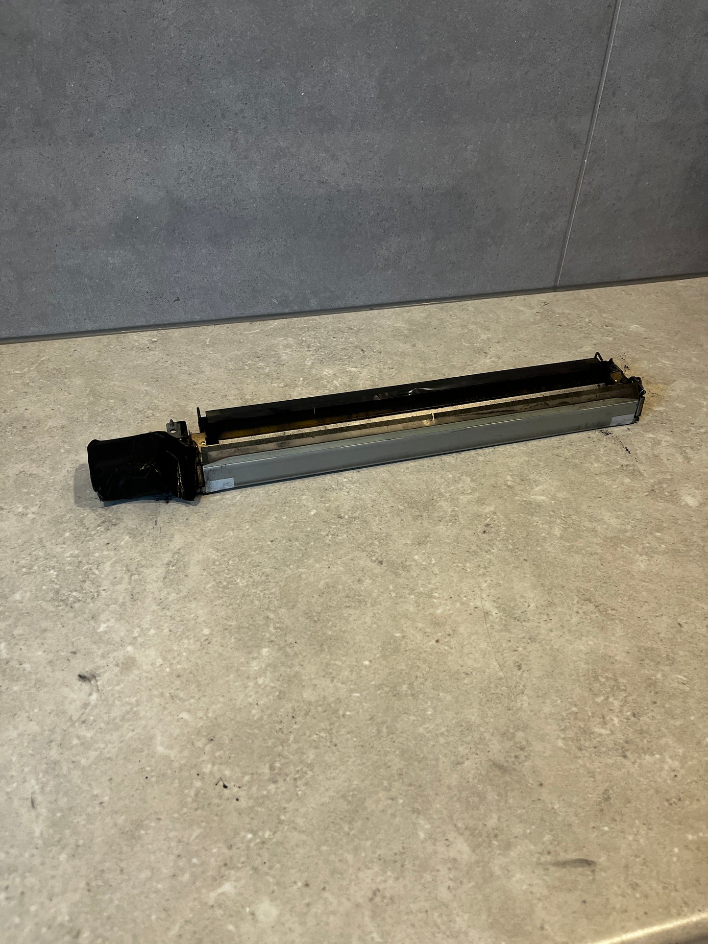 Top view of printer fuser assembly replacement showing black and metallic parts