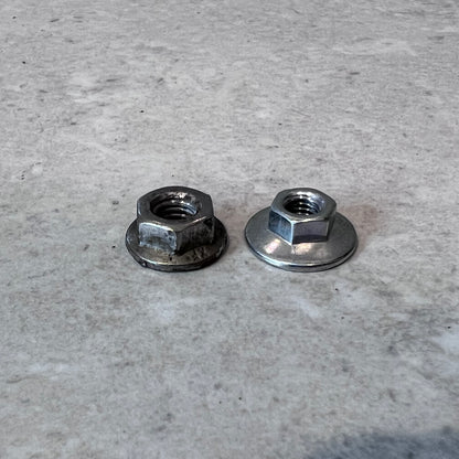 Two metal flange nuts side by side on a light surface