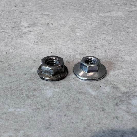 Two metal flange nuts side by side on a light surface