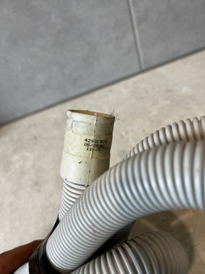 Close-up of the plastic drain hose connector with printed codes