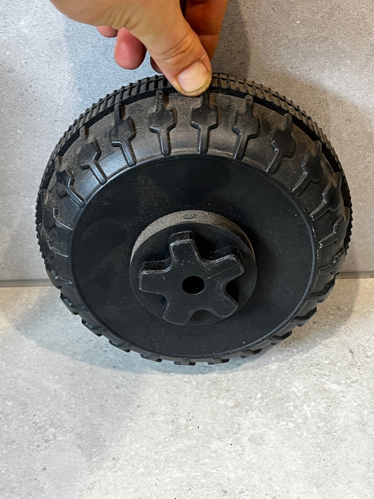 Person holding 200x100 heavy-duty replacement wheel with reinforced hub