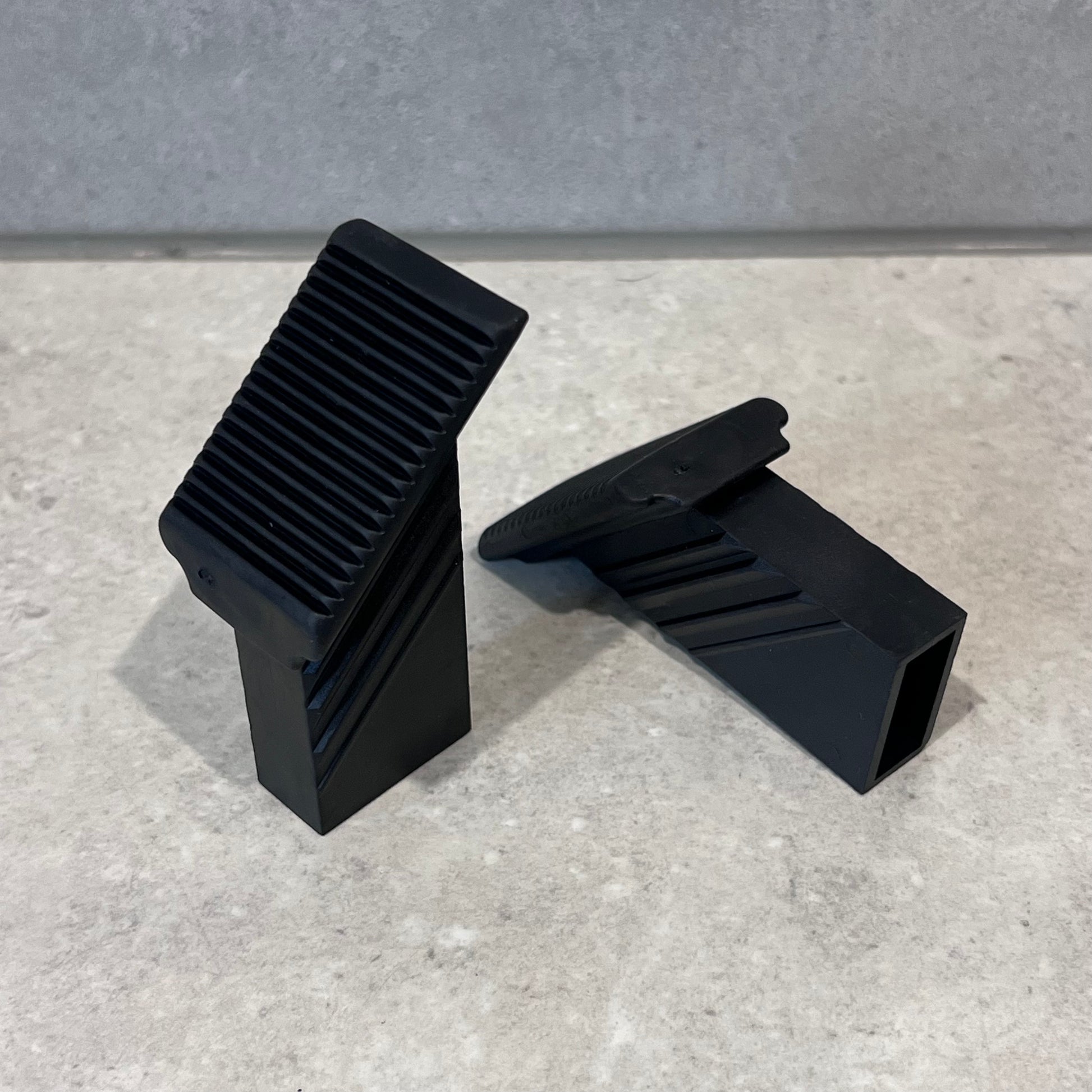 Two black plastic Krause foot caps for ladder or furniture legs