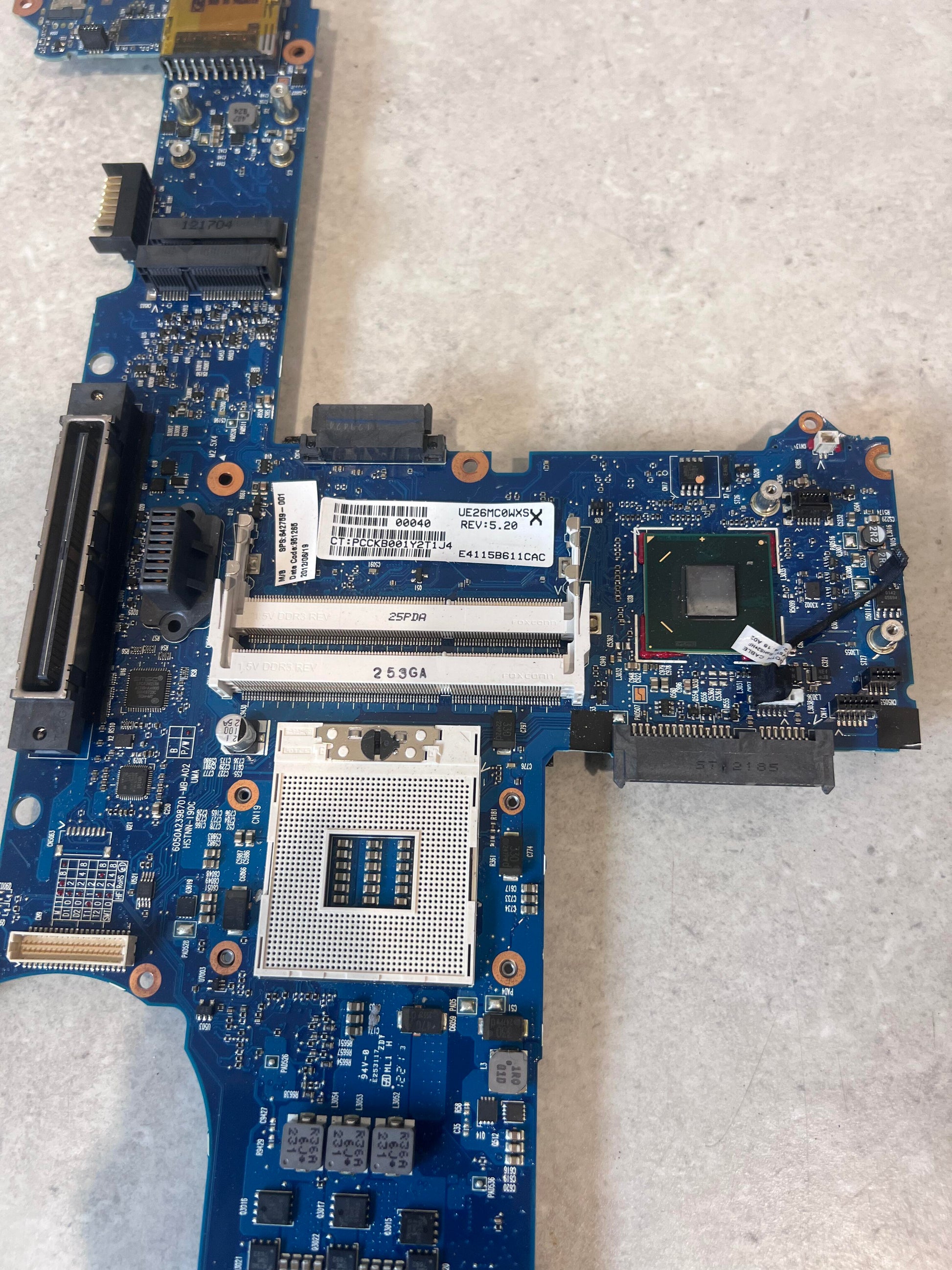Close-up of CPU socket and RAM slots on blue laptop mainboard