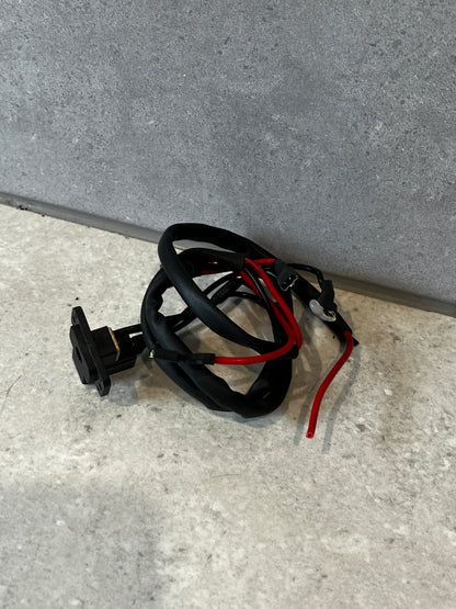 Power outlet socket with black and red insulated wires coiled on gray background