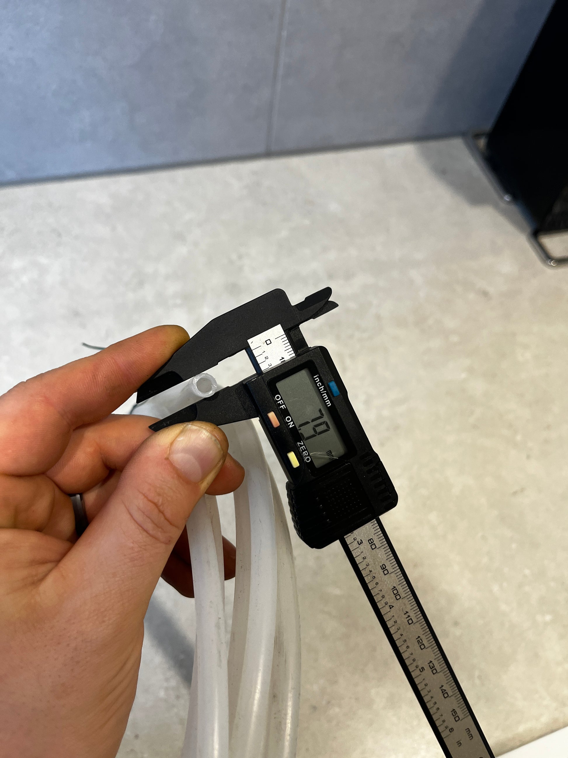 Close-up of digital caliper measuring inner diameter of tubing at 7.9 mm