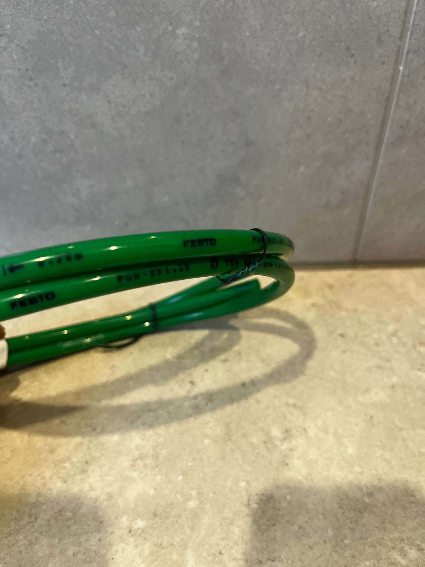 Close-up of green pneumatic tubing with printed markings