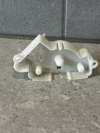 Rear view of white plastic mechanical lever bracket showing attachment pegs