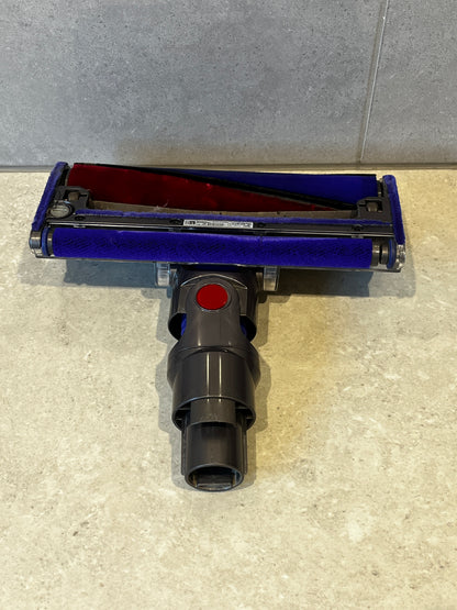 Bottom view of Dyson vacuum brush head showing soft blue and red fabric roller