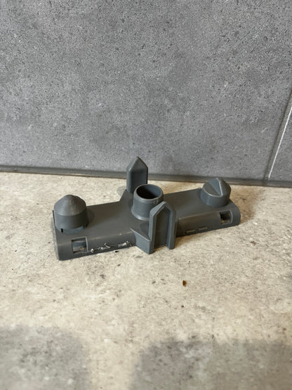 Gray plastic mounting bracket displayed on stone surface from top angle