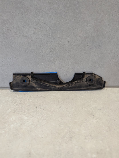 Reverse side of black plastic automotive engine cover bracket showing mounting details