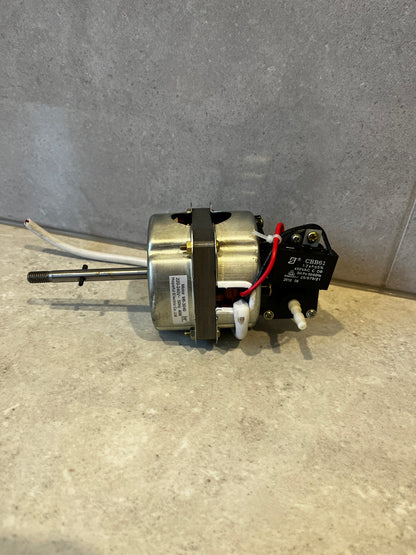 Electric fan motor with wiring and capacitor visible, positioned sideways on surface