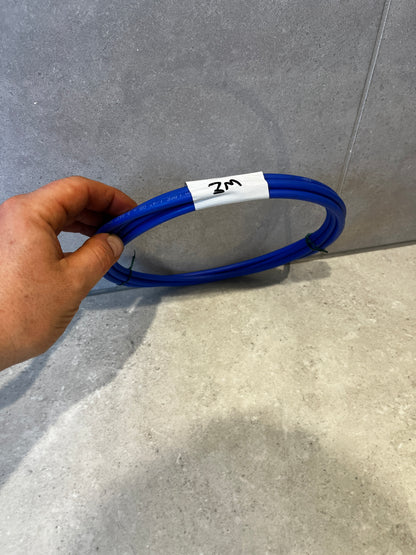 Hand holding a coiled blue electrical cable labeled '2M' against a tiled background