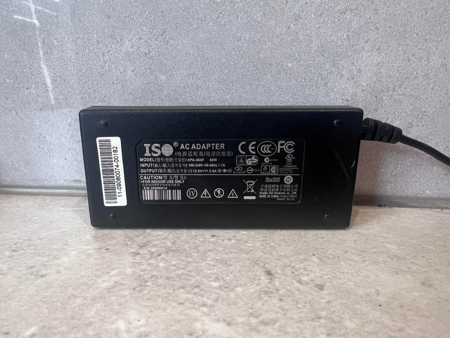 Close-up of ISO AC adapter label showing specifications and certifications