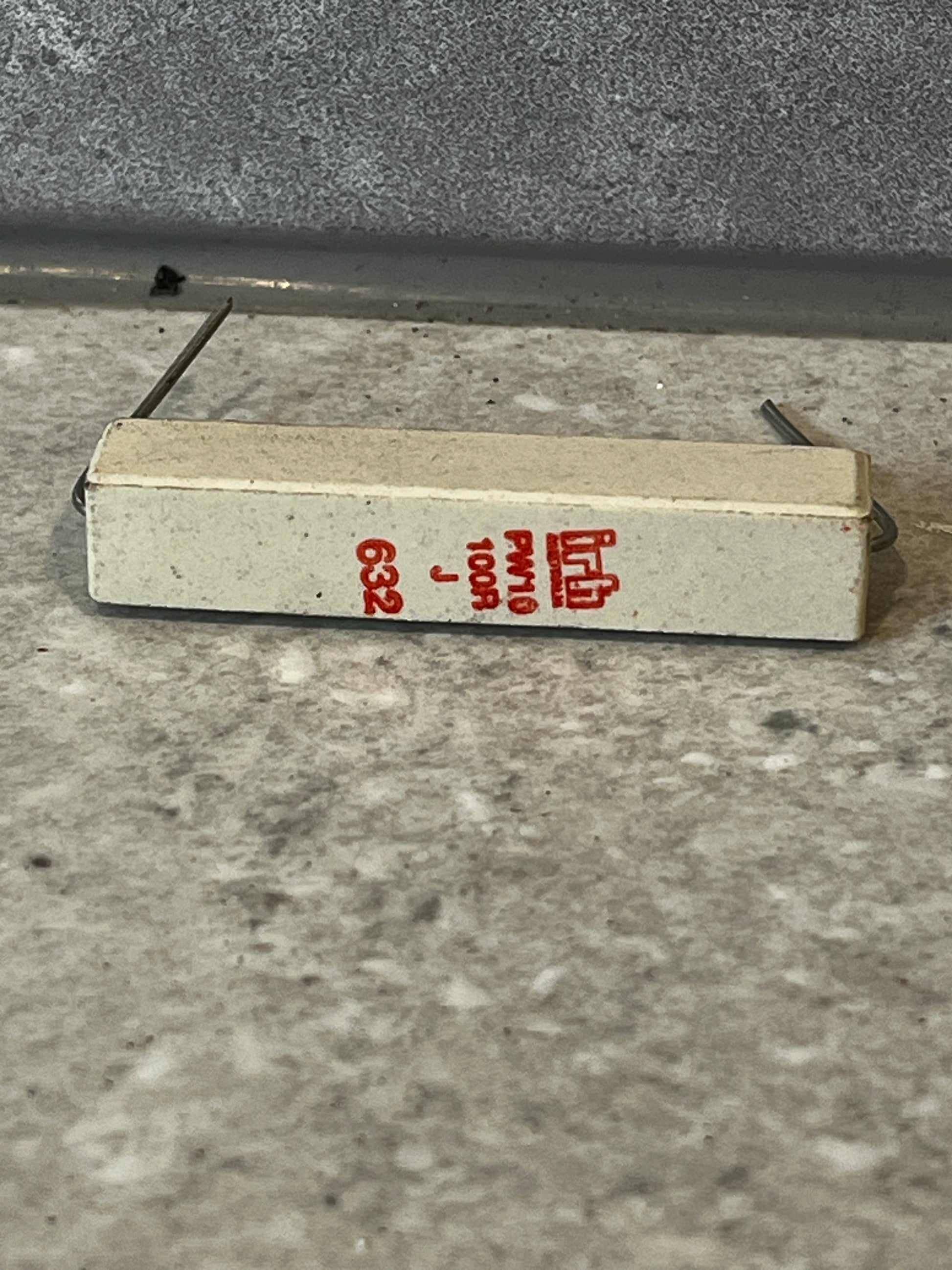 Side view of ceramic power resistor showing red markings and extended wire leads
