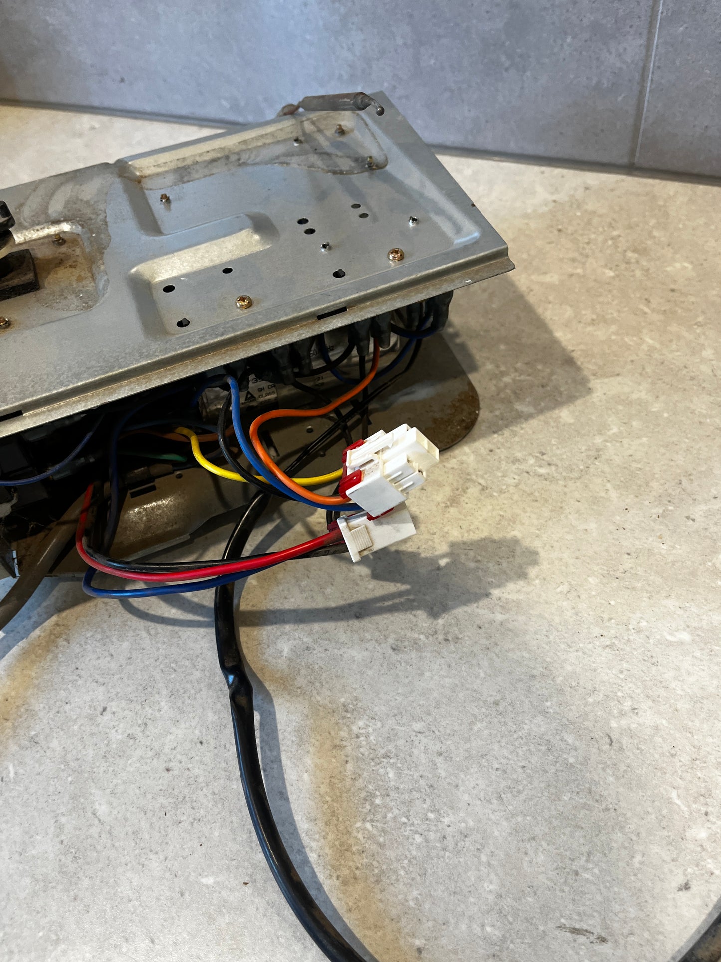 Close-up view of wiring harness connectors on thermostat control panel assembly