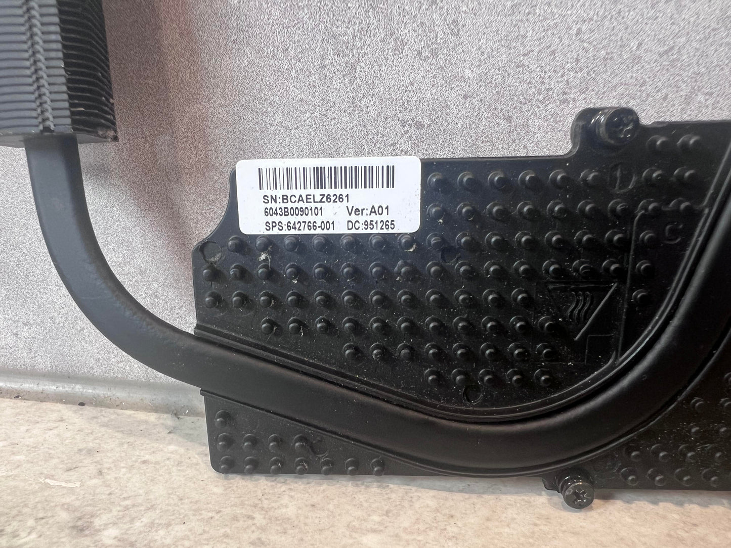 Close-up of HP laptop heatsink label and textured mounting surface
