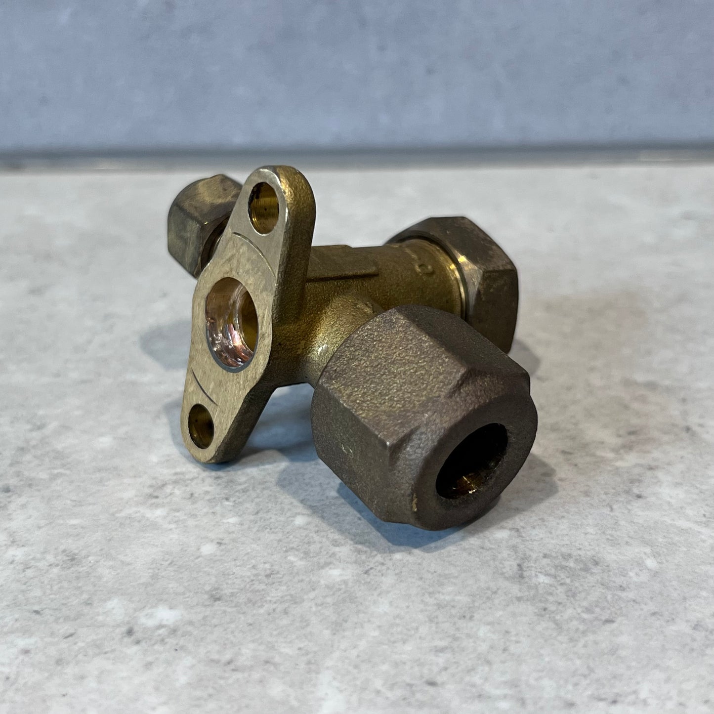 Angled side view of 3-way brass service valve highlighting fittings