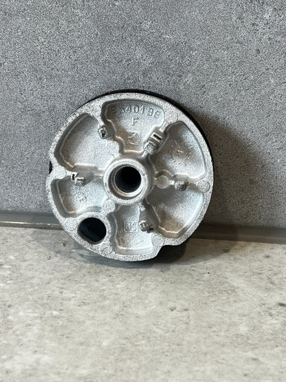 Underside of round metal furniture glide showing detailed metal construction