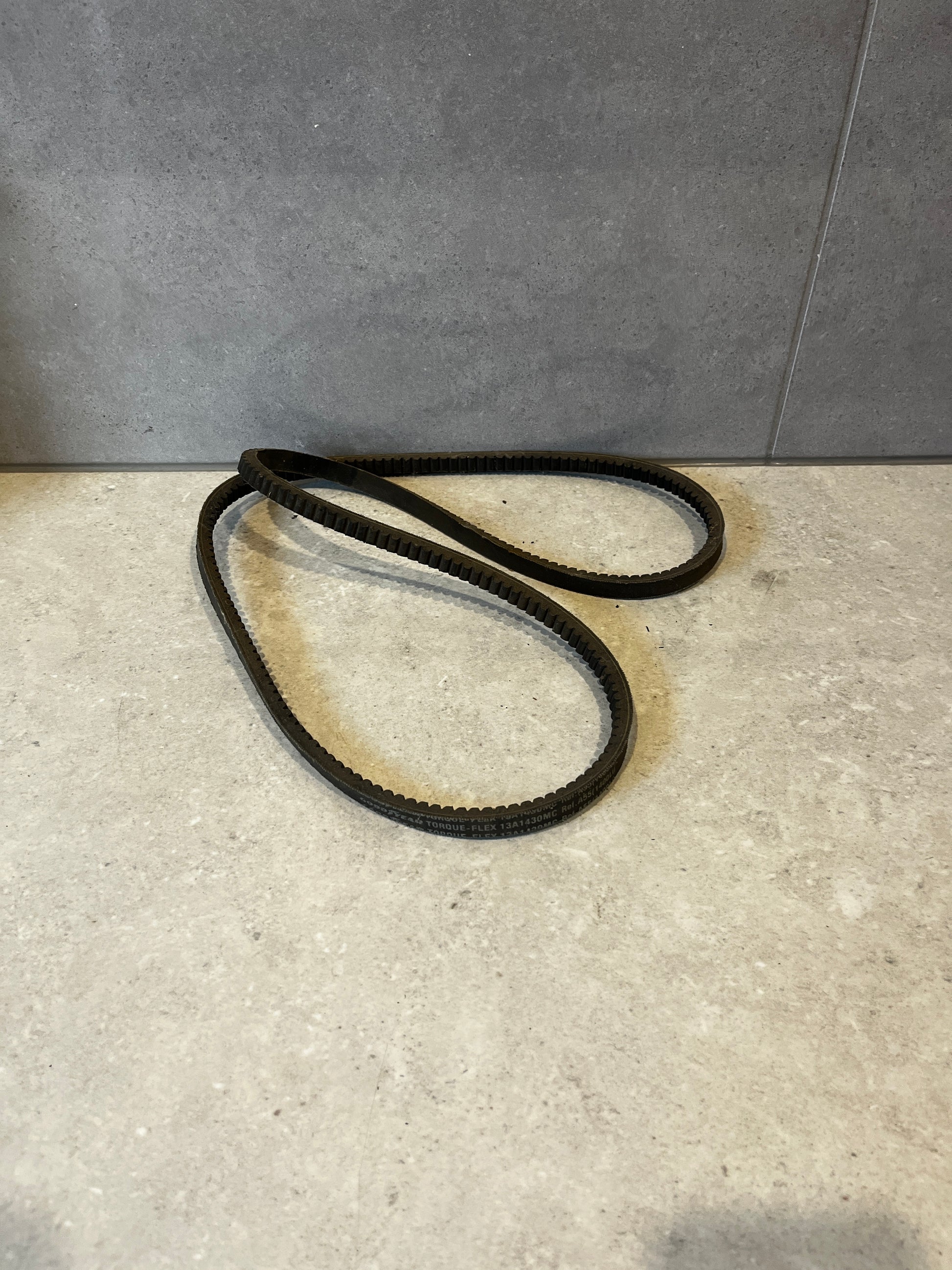 Goodyear Torque-Flex V-belt folded in a loop on gray background