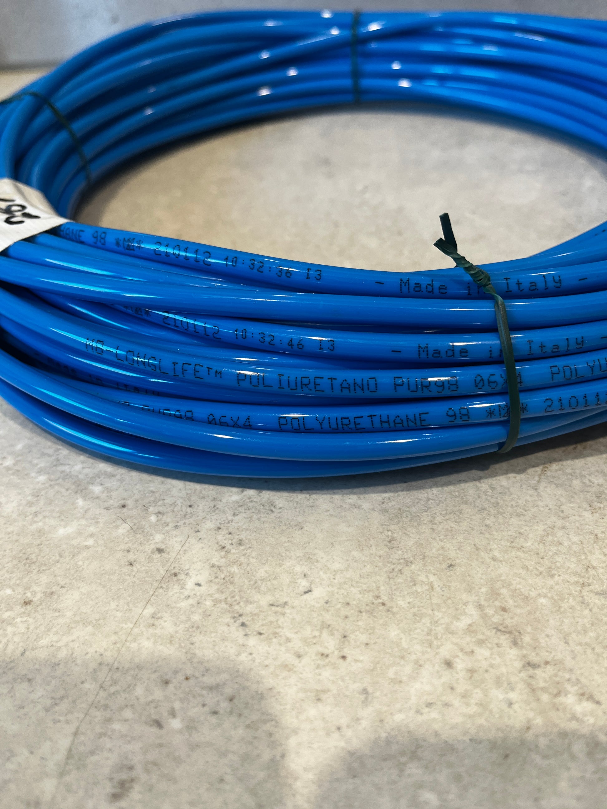 Close-up view showing printed text 'Made in Italy' and material details on blue polyurethane tubing