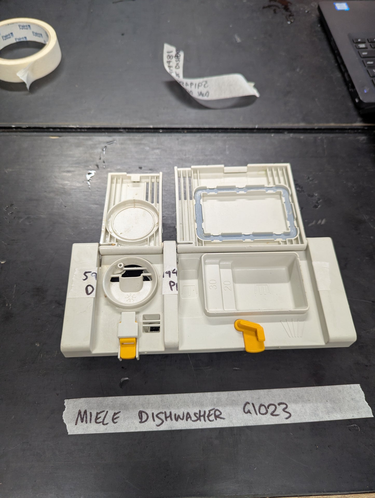 Open view showing compartments of Miele G1023 dishwasher dual detergent dispenser