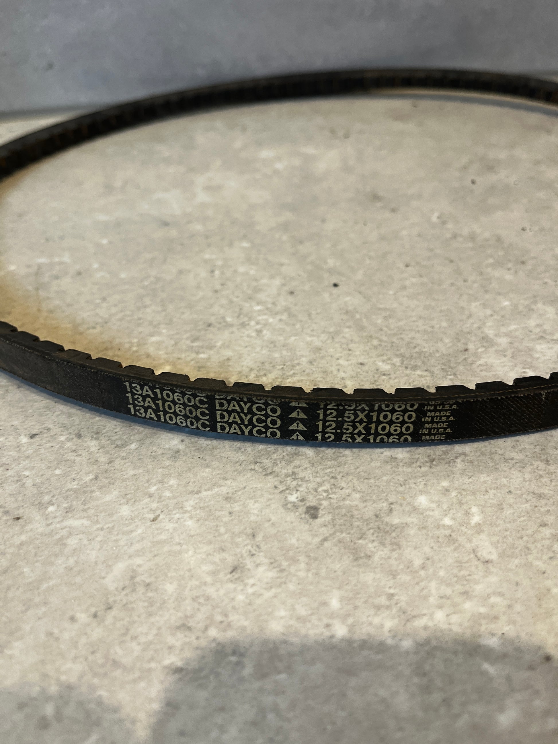Close-up of Dayco 13A1060C Drive V-Belt with clear product markings