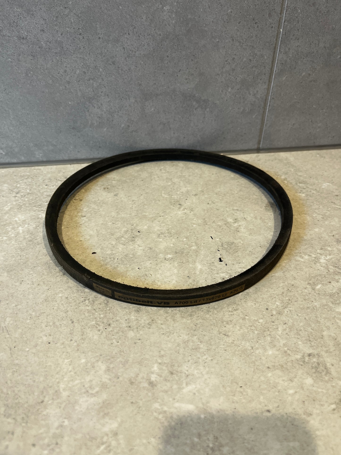 Single industrial V-belt laid flat on a countertop surface